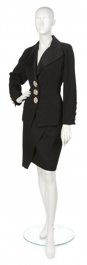 An Yves Saint Laurent Black Wool Evening Suit, Siz: An Yves Saint Laurent Black Wool Evening Suit, 1980s, satin lapel and large rhinestone buttons. Labeled: Yves Saint Laurent. Size 40.