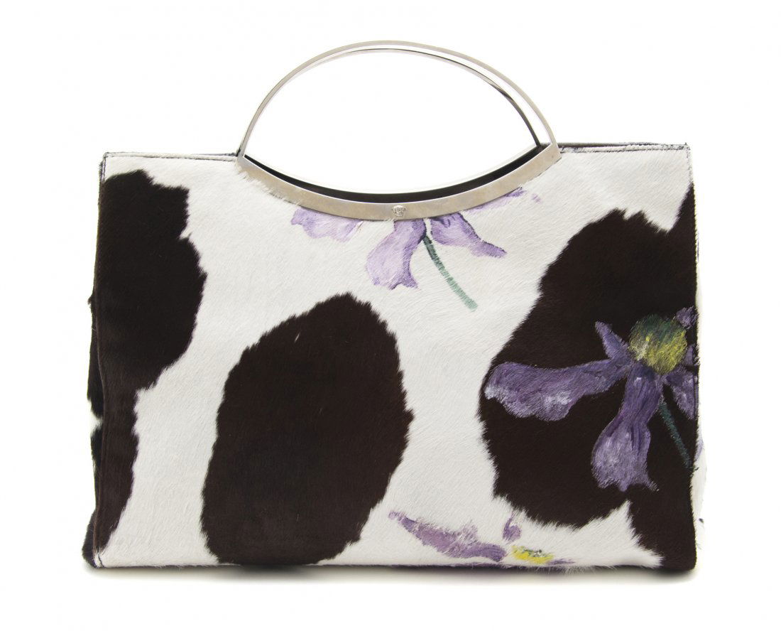 A Gianni Versace Hand Painted Pony Hair Bag, 13 x: A Gianni Versace Hand Painted Pony Hair Bag, 1990s, hand painted purple irises on brown and white pony hair, silvertone metal handles with small medusas on each. Labeled: Gianni Versace. 13 x 9 x 6 in