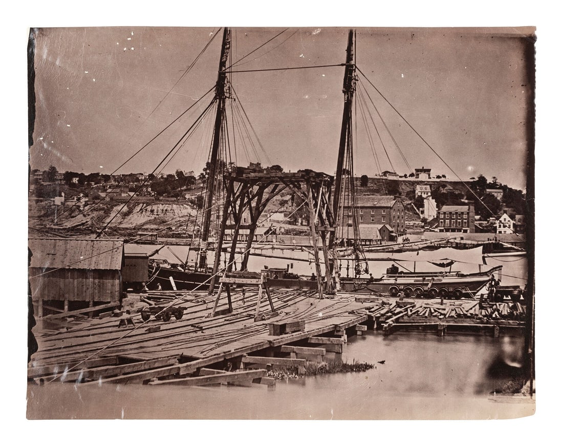[CIVIL WAR]. Possibly by John REEKIE (active 1860s), or Alexander GARDNER (1821-1882),: [CIVIL WAR]. Possibly by John REEKIE (active 1860s), or Alexander GARDNER (1821-1882), photographers. Wharf, South Side of James River, Opposite Richmond, Virginia. Ca 1865. 6 1/2 x 8 3/8 in. albumen
