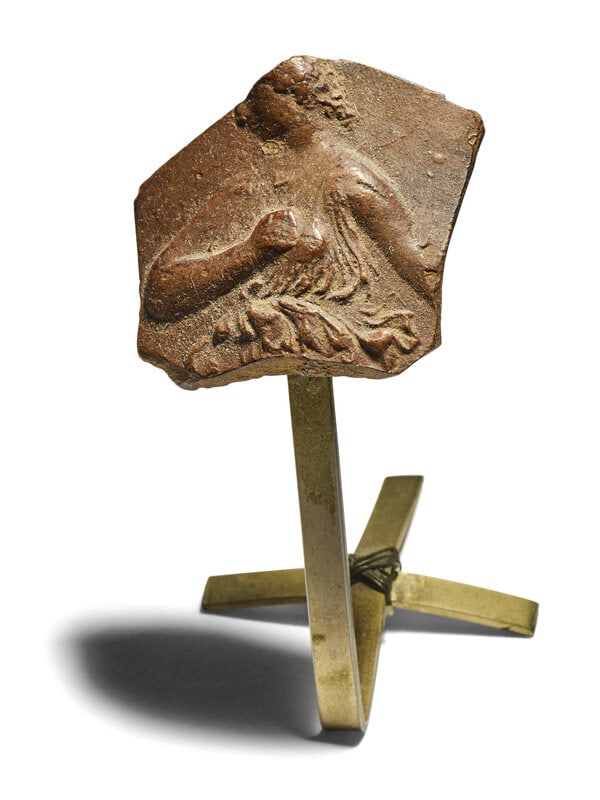 A Hellenistic Red-Ware Fragment with a Robed Woman: A Hellenistic Red-Ware Fragment with a Robed Woman Circa 3rd-2nd Century B.C. 1 1/4 x 1 1/4 inches. This lot is located in Chicago. Condition This is a fragmen