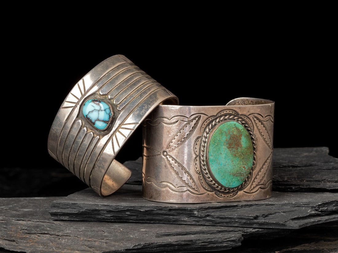 Navajo Wide Silver and Turquoise Cuff Bracelets: Navajo Wide Silver and Turquoise Cuff Bracelets mid-20th century lot of 2, includes: one with stamped pinwheel designs accentuating a central turquoise cabochon in a twisted wire bezel; marked STERLIN