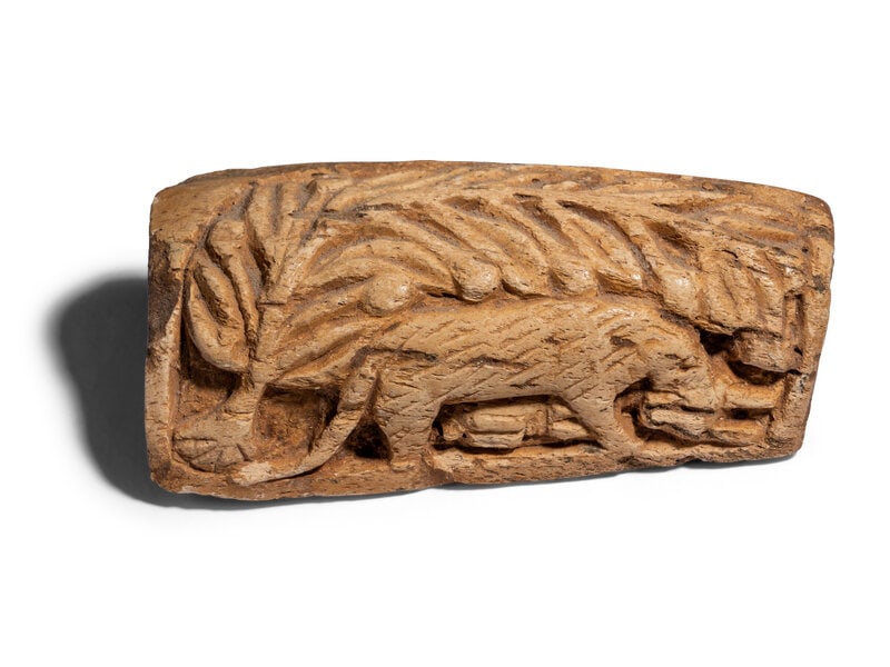 A Coptic Bone Fragment with a Lion Hunting Scene: A Coptic Bone Fragment with a Lion Hunting Scene Circa 5th-6th Century A.D. Width 3 3/4 inches (9.53 cm). Size Width 3 3/4 inches (9.53 cm). Condition Height with stand