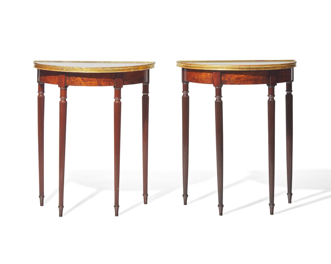 A pair of George III parcel-gilt mahogany demilune console tables with inset  tops, circa 1810 and (1 of 3)