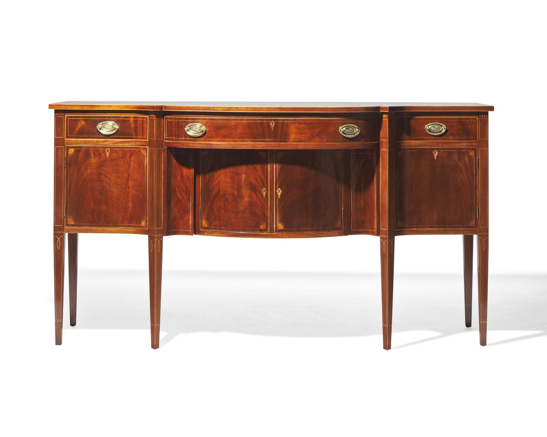 A Federal style inlaid mahogany sideboard, 20th century: A Federal style inlaid mahogany sideboard, 20th century With serpentine top, over three drawers, above two doors flanked by two side doors, revealing interior storage compartments, on tapered legs. H: