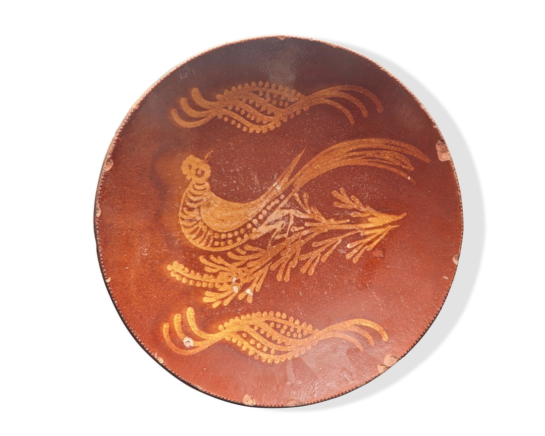 A Glazed and Slip-Decorated Redware Charger, 19th Century: A Glazed and Slip-Decorated Redware Charger, 19th Century Decorated with the figure of bird on a branch. Dia: 13 1/2 in. This lot is located in Philadelphia. The Collection of Dr. Richard J. and Eva W