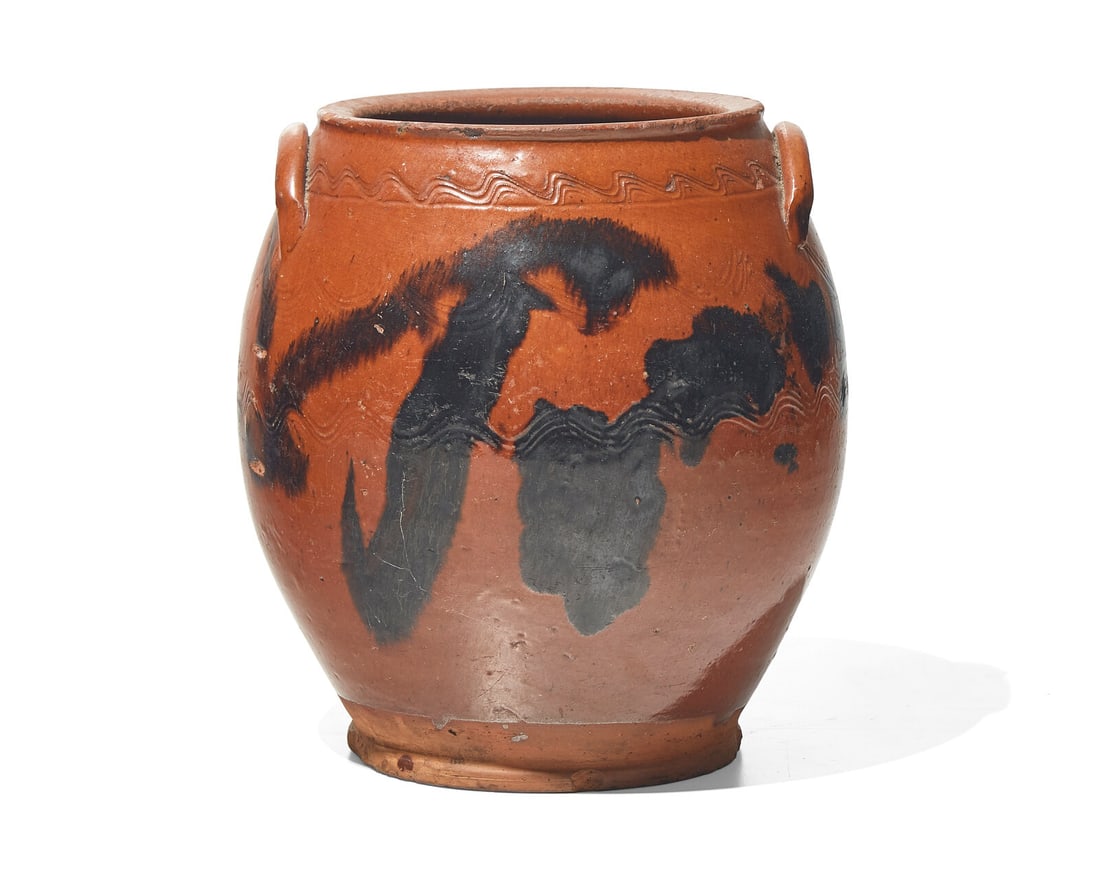 An Incised, Glazed, and Manganese-Splashed Redware Crock, 19th Century: An Incised, Glazed, and Manganese-Splashed Redware Crock, 19th Century Incised with undulating lines and swags. ?H: 9 1/4 in. This lot is located in Philadelphia. The Collection of Dr. Richard J. and
