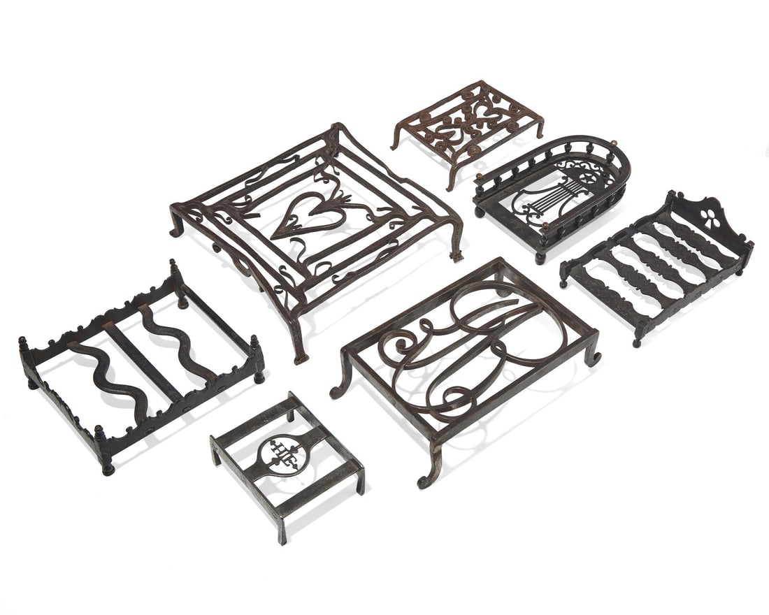 A Group of Seven Wrought Iron Trivets or Stands, French, 18th / Early 19th Century: A Group of Seven Wrought Iron Trivets or Stands, French, 18th / Early 19th Century Of various forms, two with heart and scroll devices; one with pierced club device; one with stylized monogram, "JB" (