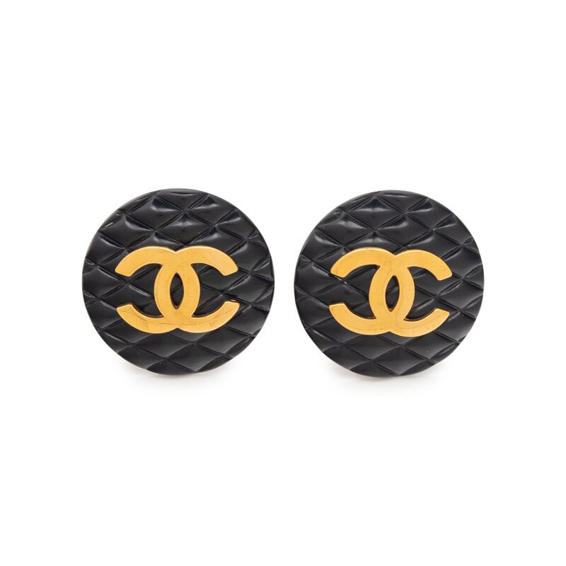 Iconic Chanel Black Quilted Gold-Tone Ear Clips: Iconic Chanel Black Quilted Gold-Tone Ear Clips Chanel large, round ear clips in black quilted-effect plastic with gold-tone metal CC motif. Label: Chanel Date: 1980s-1990s Approximate D