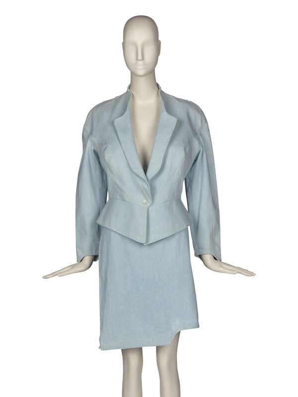 Thierry Mugler Denim Skirt Suit, 1980s : Thierry Mugler Denim Skirt Suit, 1980s THE FIRST Light-wash collarless denim jacket. Dropped shoulder. Paneled construction. Slight peplum effect. Asymmetric cut at sleeve cuffs which matches the