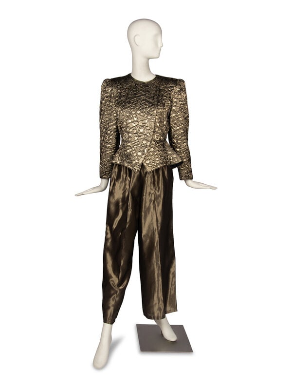 Mary McFadden Gold Pantsuit: ﻿Mary McFadden Gold Pantsuit THE FIRST Collarless asymmetric-front peplum jacket in gold matelassé lamé. Hidden zipper closure with snaps. Puff sleeves and shoulder pads. Fully li