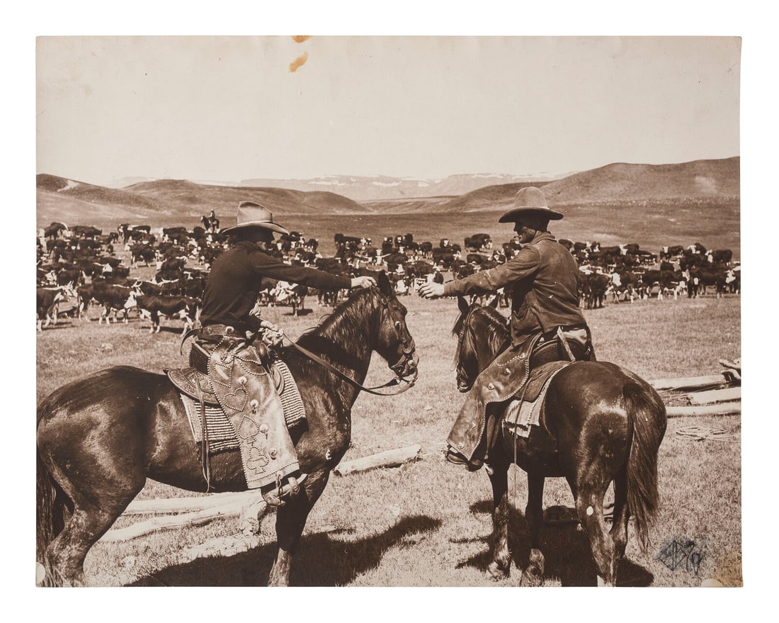 [WESTERN AMERICANA]. BELDEN, Charles J. (1888-1963), photographer. Silver gelatin photograph of: [WESTERN AMERICANA]. BELDEN, Charles J. (1888-1963), photographer. Silver gelatin photograph of cowboys sharing a pack of Camel "Tailor Made" cigarettes. Pitchfork Ranch, WY, ca 1920s-1930s. 11 x 14 i