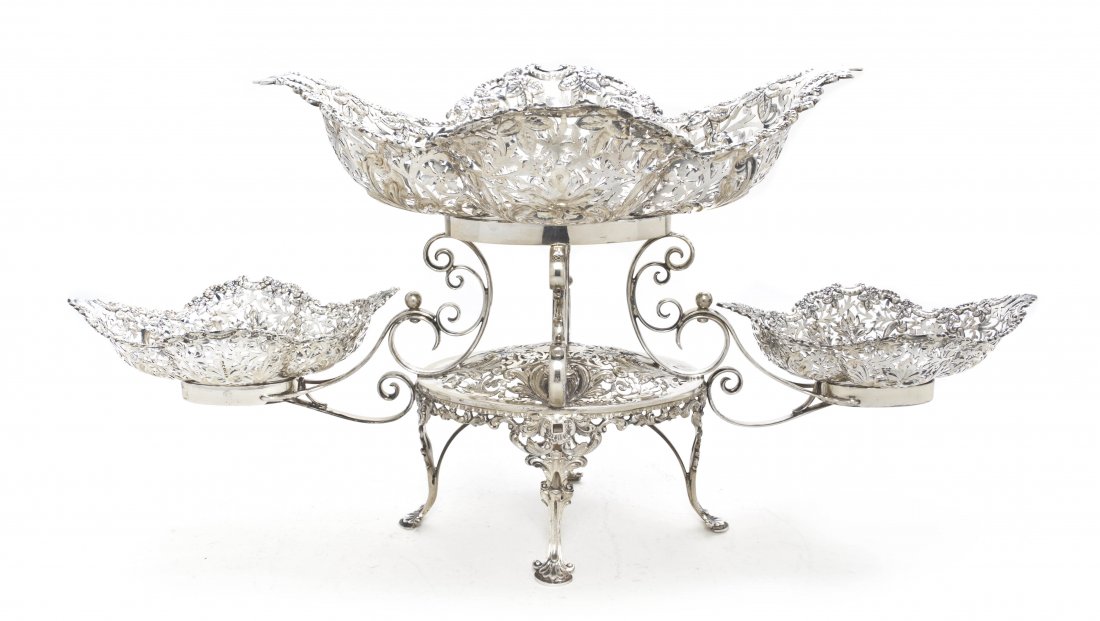 An Edwardian Silver Epergne, James Dixon & Sons, W: An Edwardian Silver Epergne, James Dixon & Sons, Sheffield, 1904, having three removable foliate decorated pierced bowls the larger flanked by the pair of smaller, raised on scrolling supports over th