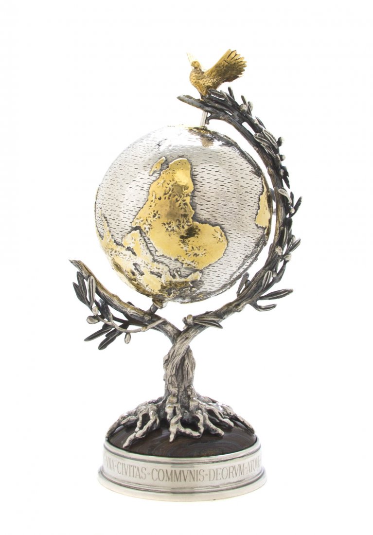 An Italian Silver and Gilt Silver Desk Globe, Bucc: An Italian Silver and Gilt Silver Desk Globe, Buccellati, titled The Millenium Globe and numbered 098/500, set in a stone mounted branch form holder with a dove form finial. Height 9 1/8 inches.