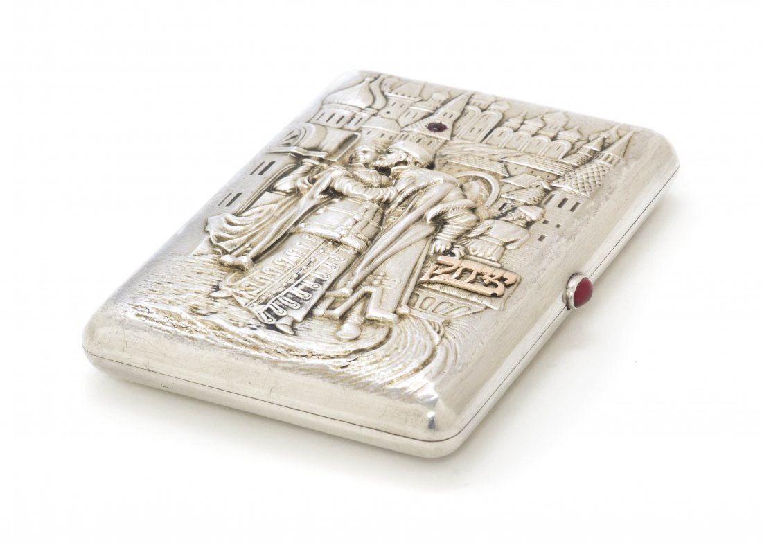 A Russian Silver, Gold and Gem Inset Cigarette Cas: A Russian Silver, Gold and Gem Inset Cigarette Case, of rectangular form, one side decorated with two figures in relief before a horse and carriage and cityscape with an inset garnet and an applied He