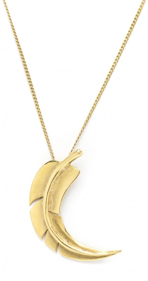 An 18 Karat Yellow Gold Feather Pendant, Angela Cu: An 18 Karat Yellow Gold Feather Pendant, Angela Cummings for Tiffany and Co., in a realistic feather design, suspended from a curb link chain. Stamp: 14787 1980 T&Co Cummings. 2.60 dwts.