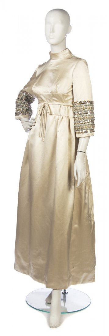A Gold Satin Evening Gown,: A Gold Satin Evening Gown, 1960s, probably Christian Dior, bell sleeves with wide bands of rhinestone, bead and pearl embellishment, stand collar, tie around waist. No label.