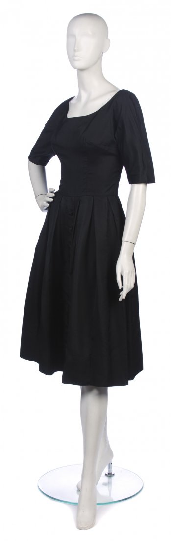 A Suzy Perette Black Dress,: A Suzy Perette Black Dress, elbow length sleeves, box pleated skirt with buttons starting at waist. Labeled: Suzy Perette. Property from a New York City Collection