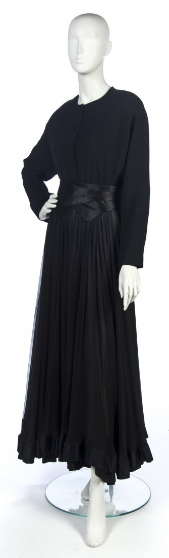 A Geoffrey Beene Black Chiffon Evening Gown,: A Geoffrey Beene Black Chiffon Evening Gown, long sleeves, silk trim around bottom, with accompanying wide black silk belt. Labeled: Geoffrey Beene / Saks Fifth Avenue.