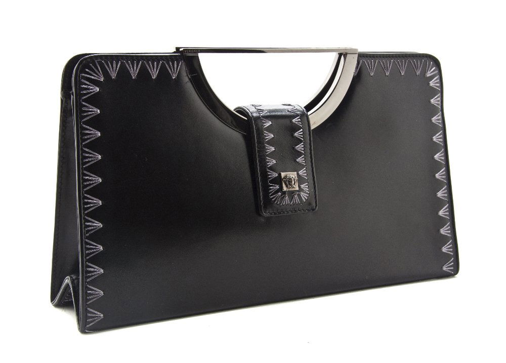 A Gianni Versace Black Leather Clutch, 11 x 6 x 2: A Gianni Versace Black Leather Clutch, trapezoid shape, silvertone metal handle, gunmetal lurex stitching embellishment around border, Medusa logo on closure flap. Stamped: Gianni Versace. 11 x 6 x 2