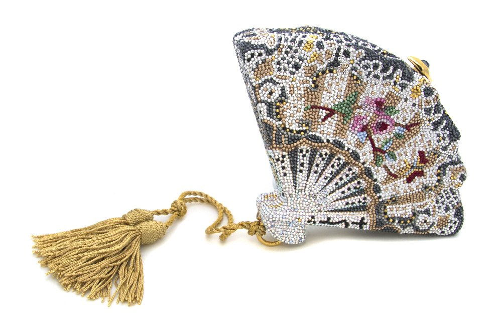 A Judith Leiber Crystal Fan Minaudiere,: A Judith Leiber Crystal Fan Minaudiere, white iridescent crystals with multicolor crystal fan decoration, gold silk tassel suspending from bottom, diamond shape gunmetal cabochon push clasp, goldtone