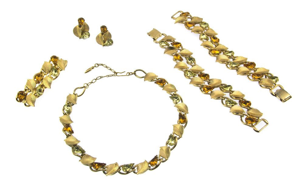 A Coro Goldtone and Rhinestone Leaf Suite,: A Coro Goldtone and Rhinestone Leaf Suite, comprised of a necklace, brooch, earclips and two bracelets with alternating leaves and pear shaped amber and pale green rhinestones. Stamped; Coro. Property