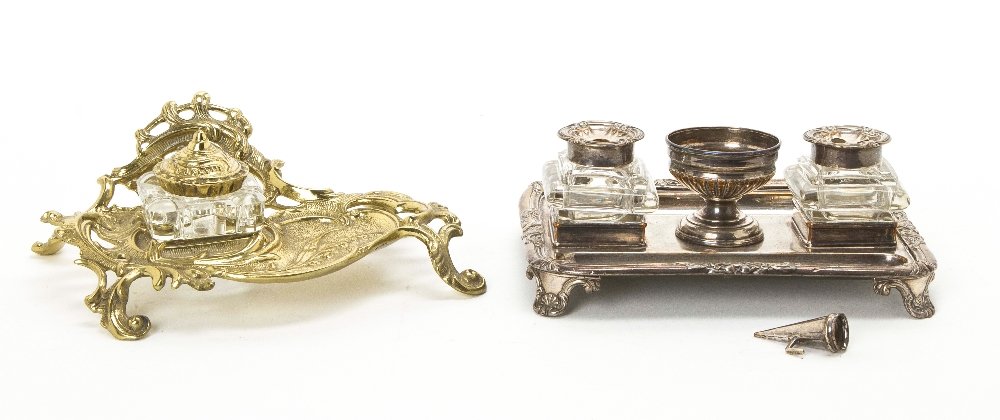 A Collection of Two Desk Articles, Length of longer : A Collection of Two Desk Articles, comprising a brass and glass Rococo style encrier, together with an English silverplate and glass standish. Length of longer 8 inches. Property from the Estate of a 
