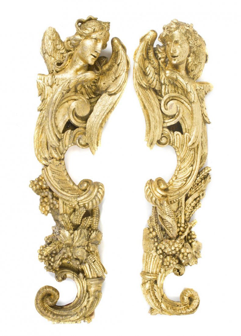 A Pair of Giltwood Wall Appliques, Height 48 inches: A Pair of Giltwood Wall Appliques, early 20th century, each depicting a winged angel head atop scrolling foliate and a cornucopia. Height 48 inches. Property from the Collection of A Gentleman, Palm B