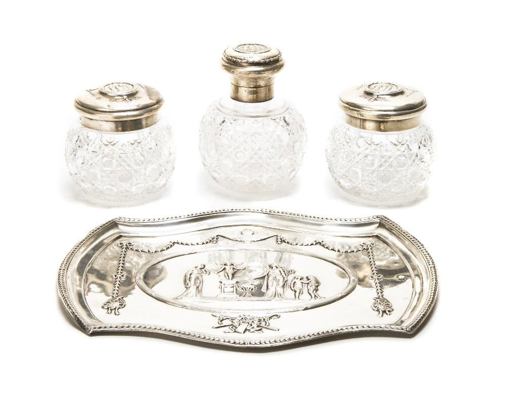 An English Silver and Cut Glass Dresser Set, Willi: An English Silver and Cut Glass Dresser Set, William Comyns & Sons, London, 1908, comprising two jars, a bottle and a tray, each decorated with classical figures; approximate weighable 12.59 ozt. Heig