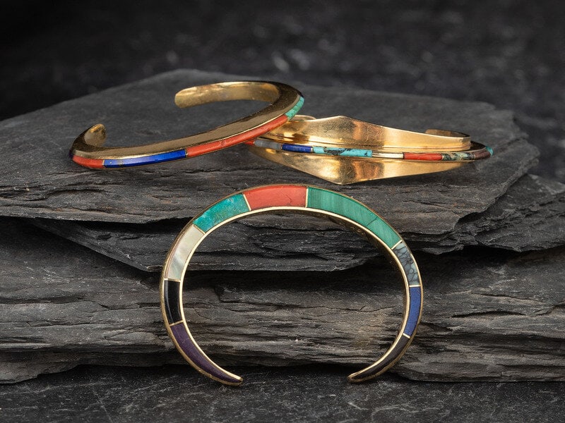 Ben Nighthorse Campbell (Northern Cheyenne, b. 1933) Inlaid Gold Cuff Bracelets: Ben Nighthorse Campbell (Northern Cheyenne, b. 1933) Inlaid Gold Cuff Bracelets lot of 3, all signed BEN NIGHTHORSE and marked with a morning star, two marked 18K and one 14K, sizes include: