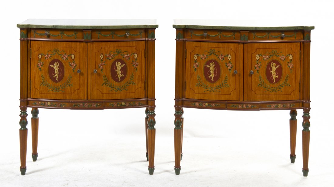 A Pair of Julia Gray Sheraton Style Console Cabin: A Pair of Julia Gray Sheraton Style Console Cabinets, the shaped rectangular top over the conforming body fitted with two drawers above two doors, raised on tapering legs with polychrome floral and sw