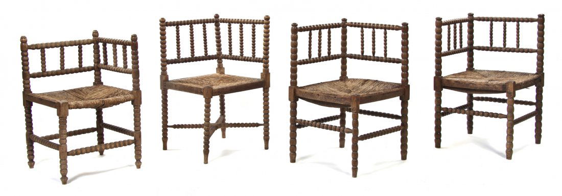 An Assembled Set of Four Victorian Corner Chairs,: An Assembled Set of Four Victorian Corner Chairs, each with a spindled back and turned supports enclosing the rush seat, the legs joined by stretchers. Height of first 27 1/2 inches.