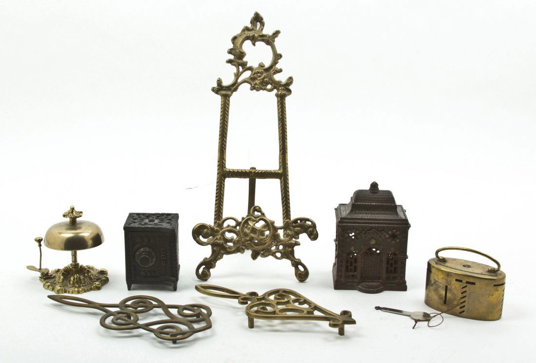 A Collection of Cast Metal Decorative Table Artic: A Collection of Cast Metal Decorative Table Articles, comprising three still banks, an easel, two trivets and a bell. Height of tallest 14 1/8 inches. Property from the Collection of Fred L. Drucker,