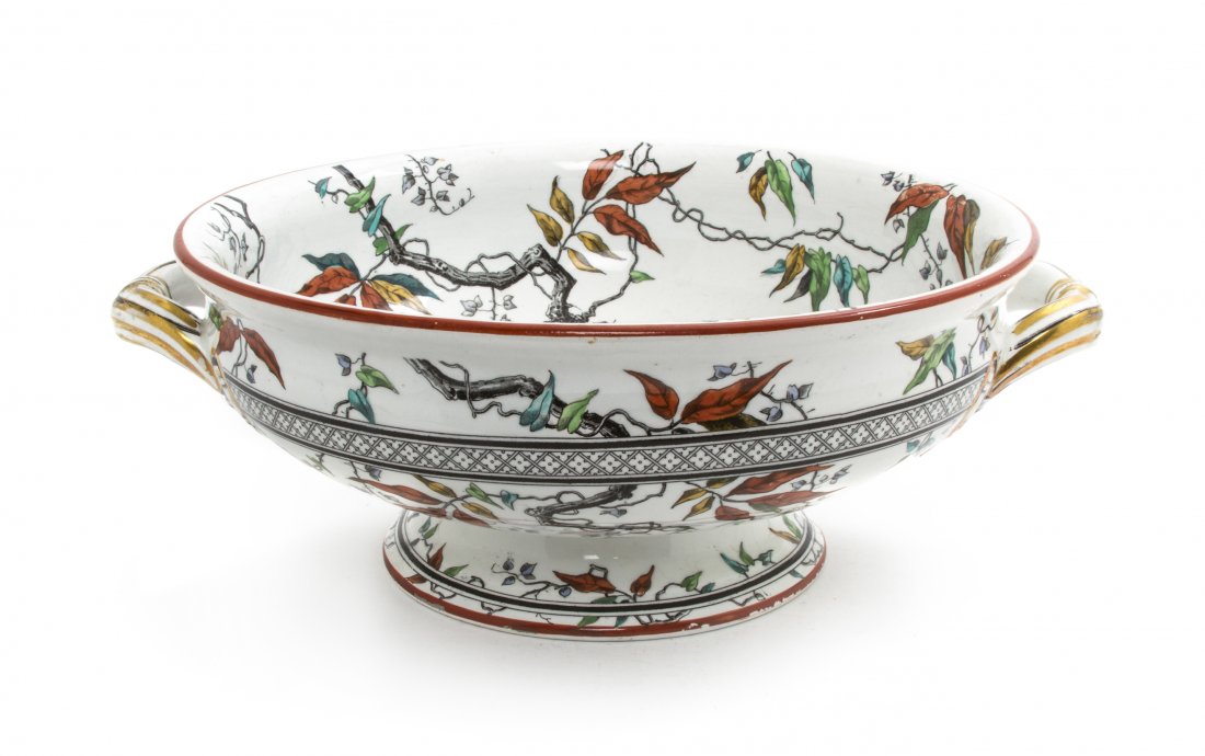An English Porcelain Center Bowl, Minton, Width o: An English Porcelain Center Bowl, Minton, of handeled form, having branch and leaf decoration throughout with gilt highlights, raised on a conforming foot. Width over handles 12 1/2 inches.