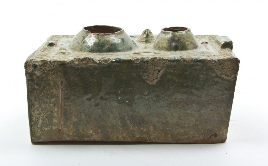 A Chinese Han Dynasty Style Ceramic Stove, Width : A Chinese Han Dynasty Style Ceramic Stove, of rectangular form having two wells to the top, surrounded by raised implements including forks and a ladle, having a mottled green glaze throughout. Width 