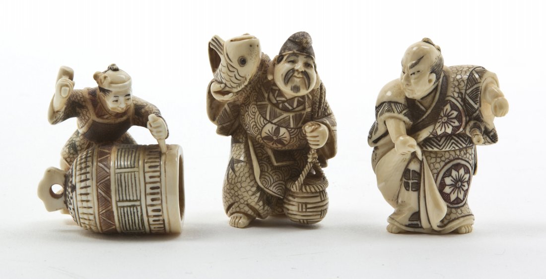 A Group of Three Japanese Carved Ivory Netsuke, H: A Group of Three Japanese Carved Ivory Netsuke, each polychrome decorated, depicting a man with a fish, one a samurai and one a man with a mallet striking a bell. Height of tallest 2 inches.