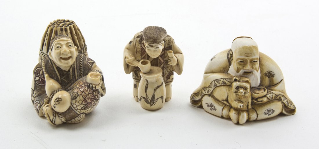 A Group of Three Japanese Carved Ivory Netsuke, H: A Group of Three Japanese Carved Ivory Netsuke, two polychrome decorated and one tea stained, depicting an old man with a cat and two laboring peasants. Height of tallest 1 5/8 inches.