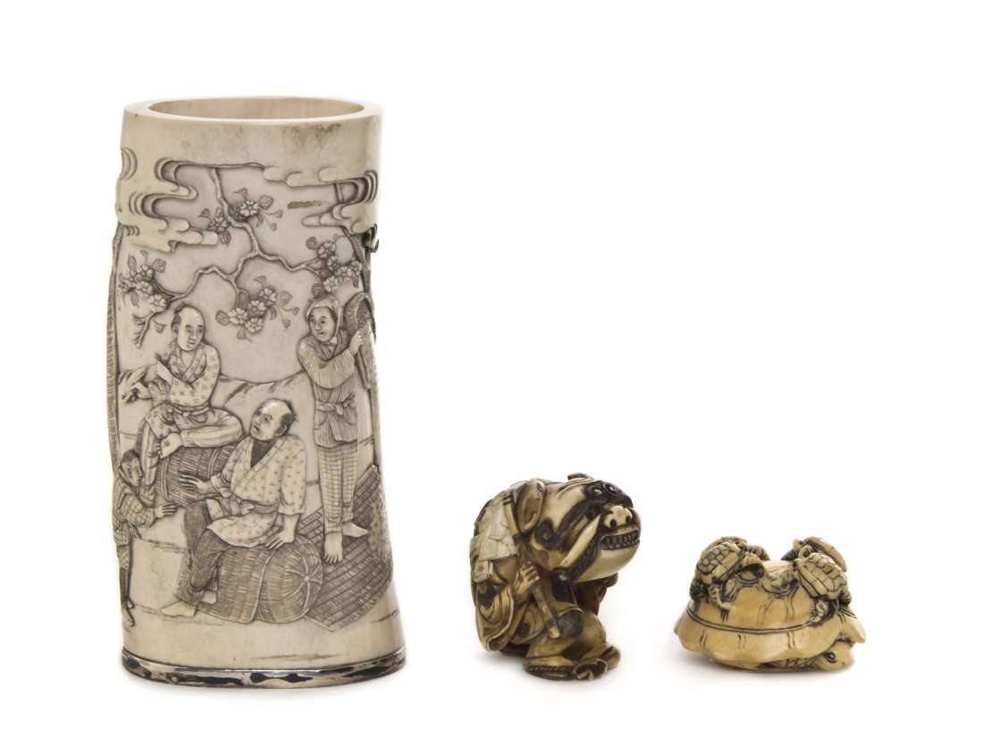 A Group of Japanese Carved Ivory Articles, Height: A Group of Japanese Carved Ivory Articles, comprising a tusk form brush pot carved with a scene of figures at work, with a band of clouds above and a silver rim at the bottom, with two netsuke, one de