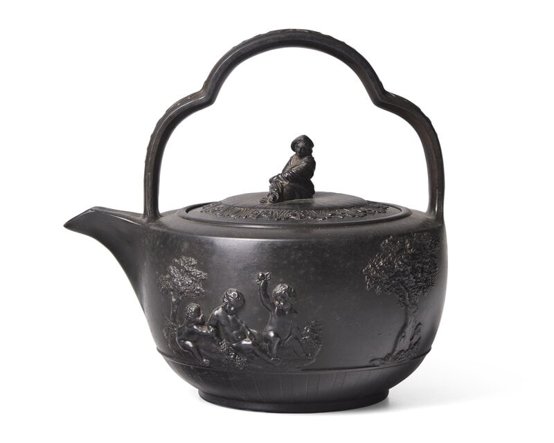 A Wedgwood Black Basalt Rum Kettle: A Wedgwood Black Basalt Rum Kettle Circa 1785 Featuring playful putti in relief and Sybil finial; impressed Wedgwood mark. Height 8 7/8 x width 9 1/4 inches. Property from the