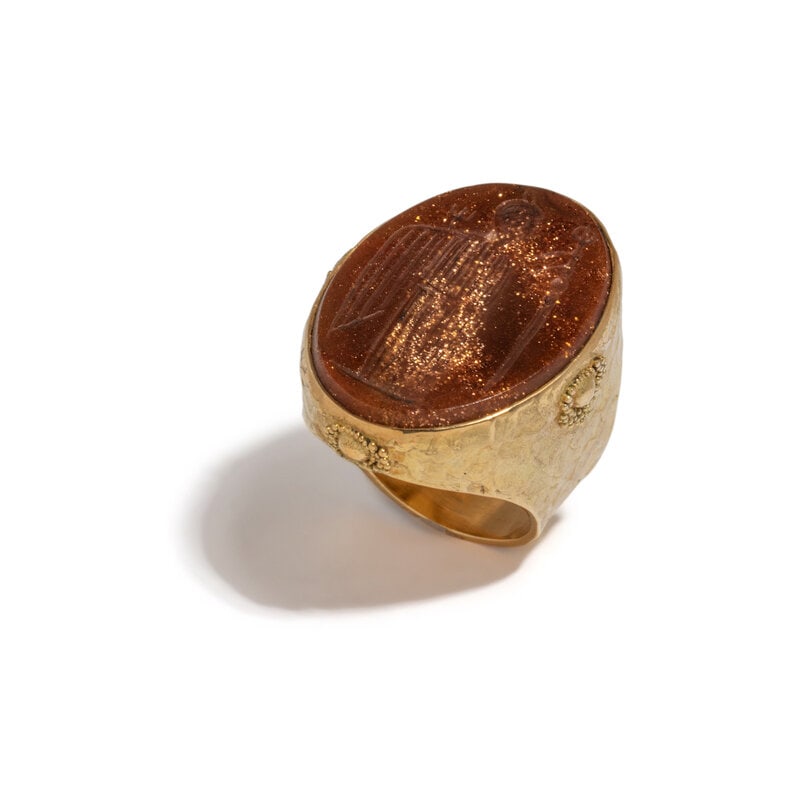 ED WIENER, YELLOW GOLD AND SUNSTONE INTAGLIO RING: ED WIENER, YELLOW GOLD AND SUNSTONE INTAGLIO RING Oval sunstone intaglio measuring approximately 28.60 x 20.70 mm. 18 karat yellow gold. Ring size 8. Stamp: EW 18K. Gross weight: 15.20 dwt. <