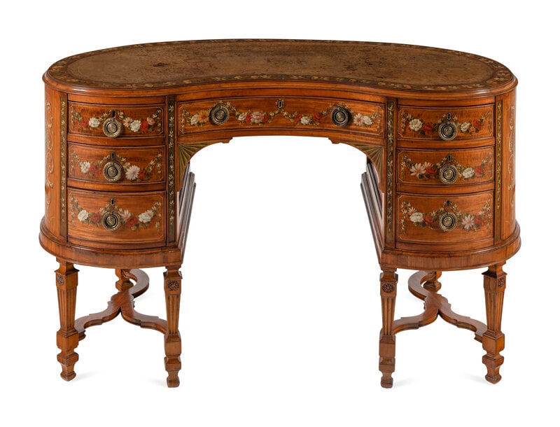An Edwardian Painted Satinwood Desk: An Edwardian Painted Satinwood Desk Early 20th Century reniform, with a gilt-tooled leather inset top. Height 31 x width 53 x depth 25 inches. This lot is located in Ch