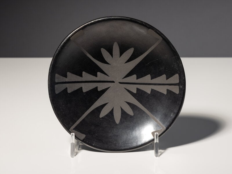 Maria Martinez and Popovi Da (San Ildefonso, 1887-1980 / 1923-1971) Matte on Black Plate, with Botan: Maria Martinez and Popovi Da (San Ildefonso, 1887-1980 / 1923-1971) Matte on Black Plate, with Botanical Designs 1956-1959 signed on base Maria/Popovi diameter 5-1/4 inches This lot