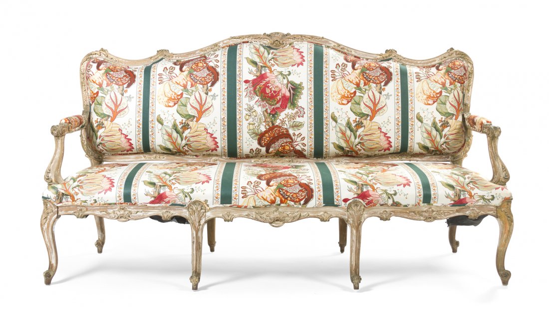 A Louis XV Style Carved and Polychrome Decorated Ca: A Louis XV Style Carved and Polychrome Decorated Canape, 19th century, with a carved scrolling crest and seat rail, with an upholstered back and seat, raised on cabriole legs. Width 73 inches. Propert