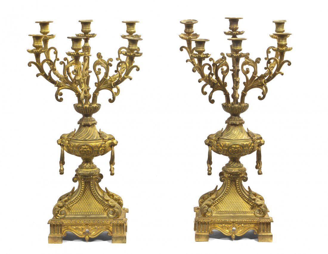 A Pair of Louis XVI Style Gilt Bronze Five-Light C: A Pair of Louis XVI Style Gilt Bronze Five-Light Candelabra, each urn form standard flanked by lion mask ring handles and issuing scrolling candle arms, raised on rectangular bases. Height 26 1/2 inch