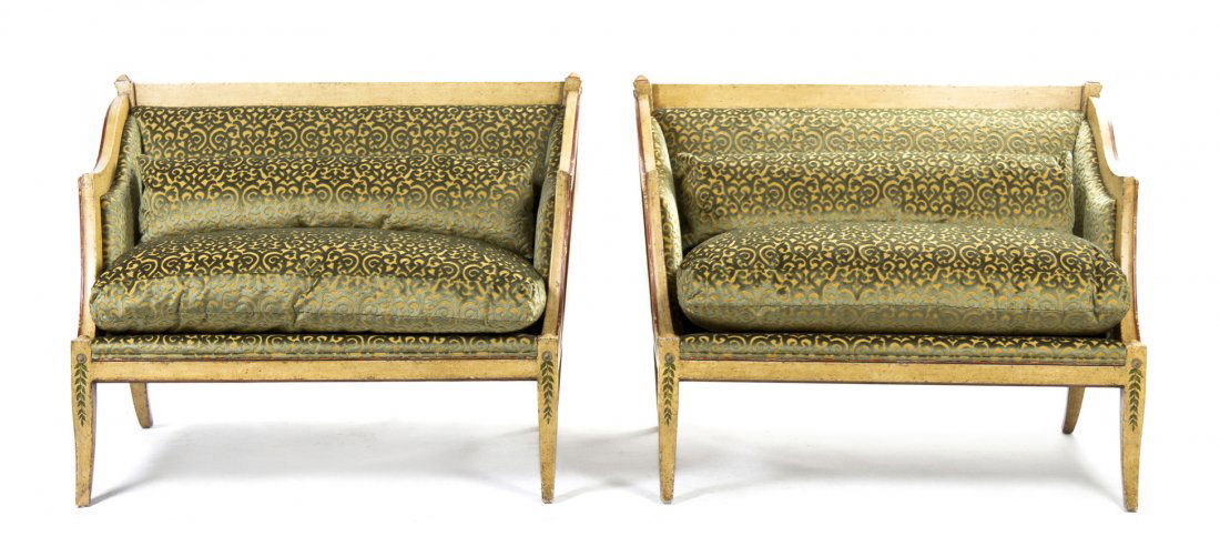 A Pair of Italian Painted Settees, Height 38 x wid: A Pair of Italian Painted Settees, each having a straight crest rail over the upholstered back, sides and seat, raised on foliate decorated sabre legs. Height 38 x width 50 x depth 29 inches.