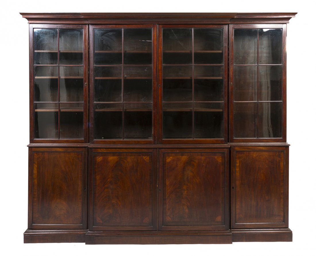 A George III Style Mahogany Breakfront Bookcase, H: A George III Style Mahogany Breakfront Bookcase, 19th century, having a molded cornice over four glazed doors and four paneled doors, each opening to a shelved interior, the whole raised on a plinth b