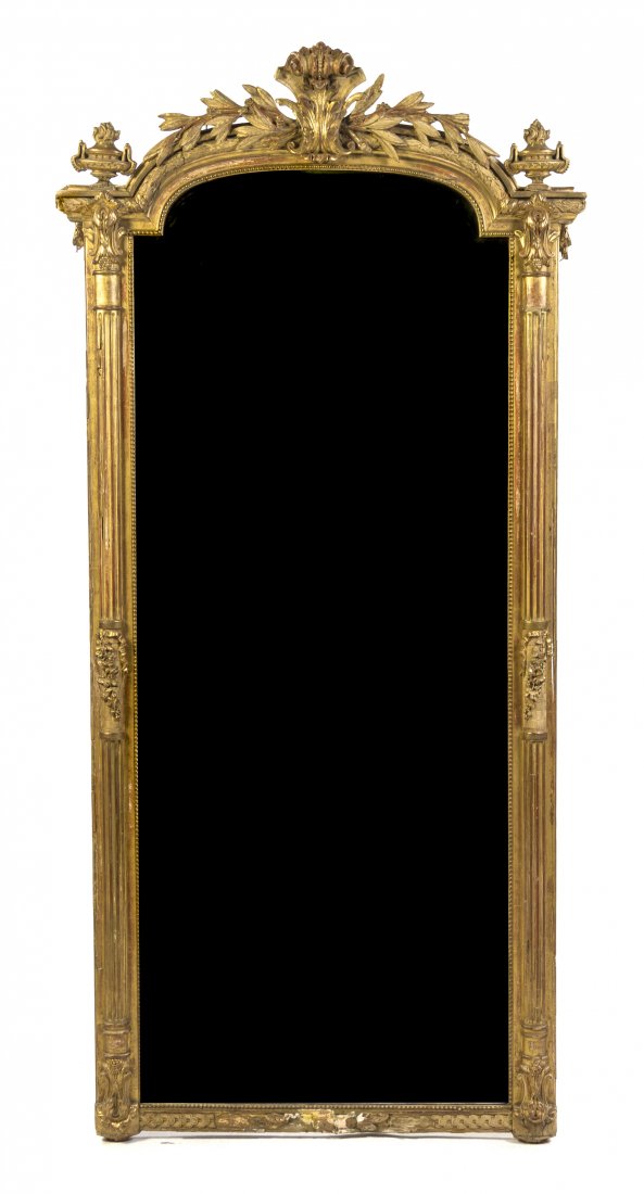 A Victorian Giltwood Pier Mirror, Height 81 x widt: A Victorian Giltwood Pier Mirror, with a scrolling foliate crest flanked by flaming urn finials over a vertical beveled plate. Height 81 x width 39 inches. Property from the Collection of Dr. and Mrs.