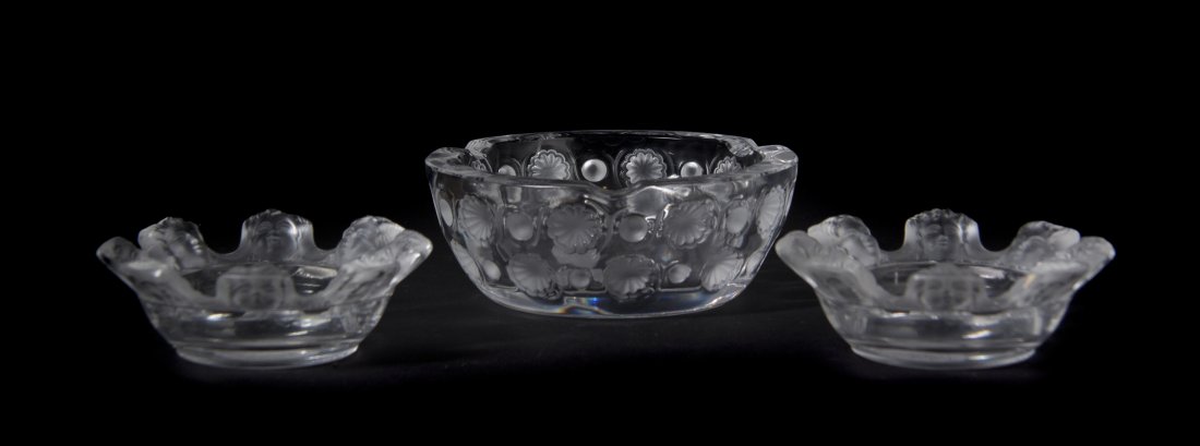 Three Lalique Molded and Frosted Glass Ash Receive: Three Lalique Molded and Frosted Glass Ash Receivers, comprising a Tokio bowl and two St. Nicolas bowls, each signed Lalique France. Diameter of largest 5 1/2 inches. Property from the Collect