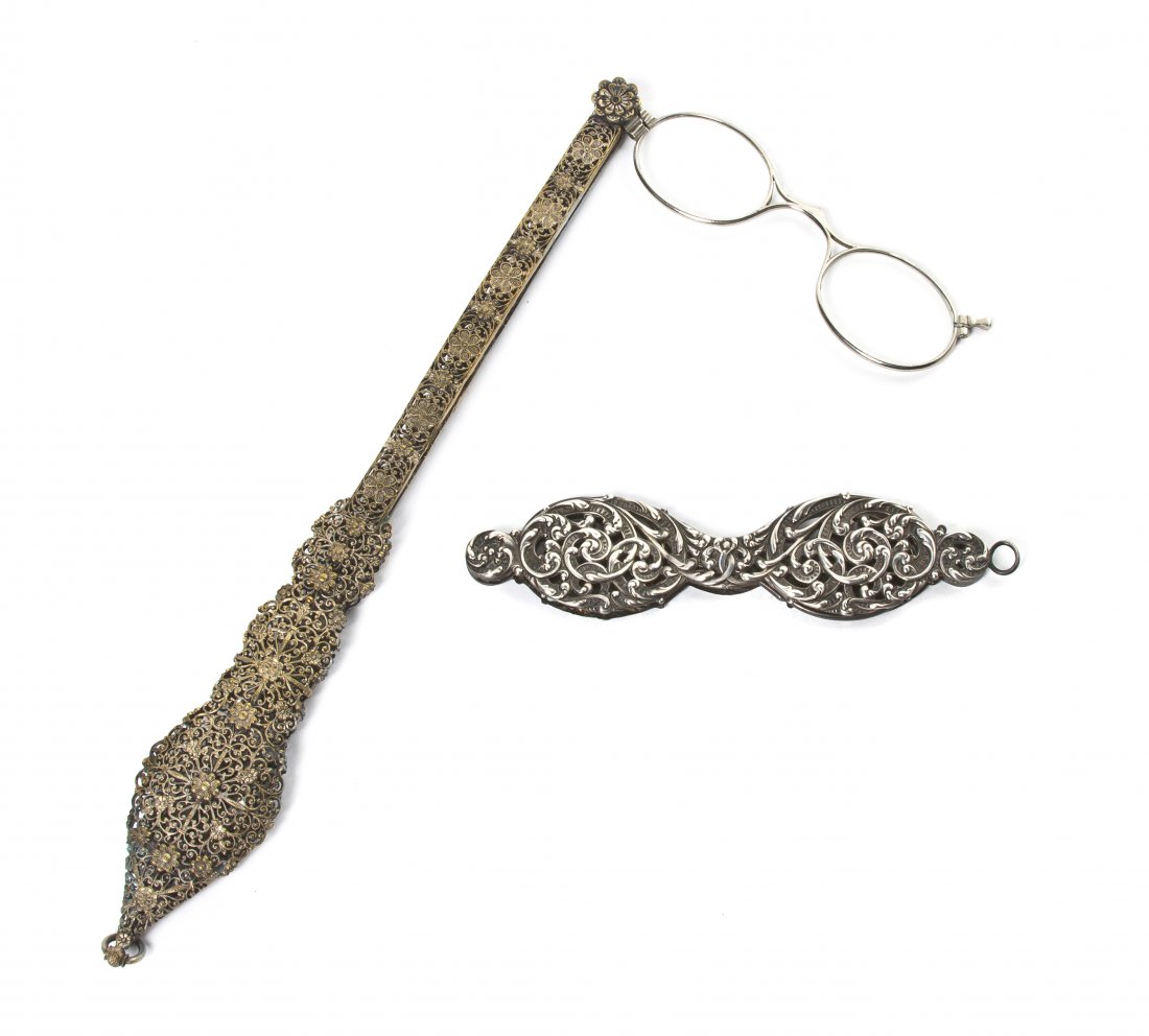 Two Silvered Metal Mounted Lorgnettes, Length of : Two Silvered Metal Mounted Lorgnettes, the first with a filigree handle, the second with pierced scrolling foliate decoration. Length of first 9 3/4 inches. Property from the Estate of Mr. Mark Fritz,