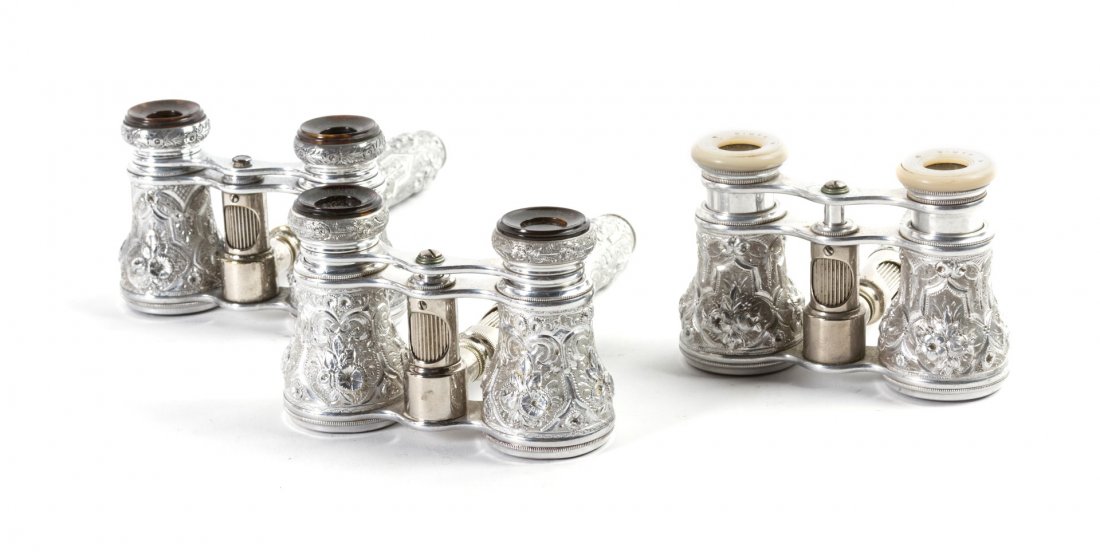 Three Pairs of French Bright Cut Aluminum Opera G: Three Pairs of French Bright Cut Aluminum Opera Glasses, comprising two Lemaire examples and another, each having a central conforming handle with a focus wheel. Width 3 7/8 inches. Property from the 