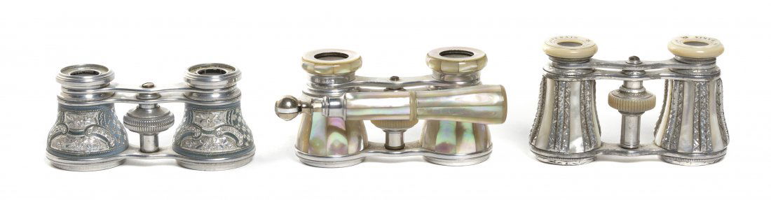 Three Pairs of Opera Glasses, Width of first 4 in: Three Pairs of Opera Glasses, two with mother-of-pearl veneers, the first Audemair, Paris, the second with handle, the third having foliate and pin wheel decoration. Width of first 4 inches. Property